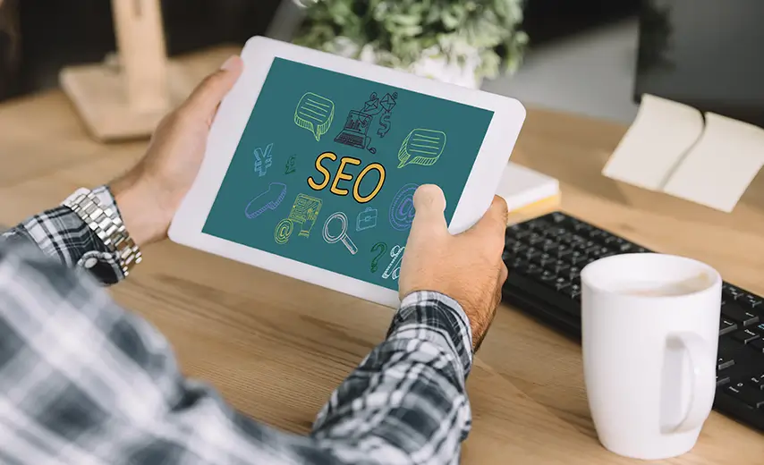 Cropped shot of developer using tablet with SEO icon